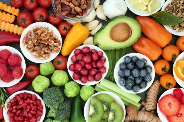 A selection of different plant foods including blueberries, avocados, kiwis, brussel sprouts and more