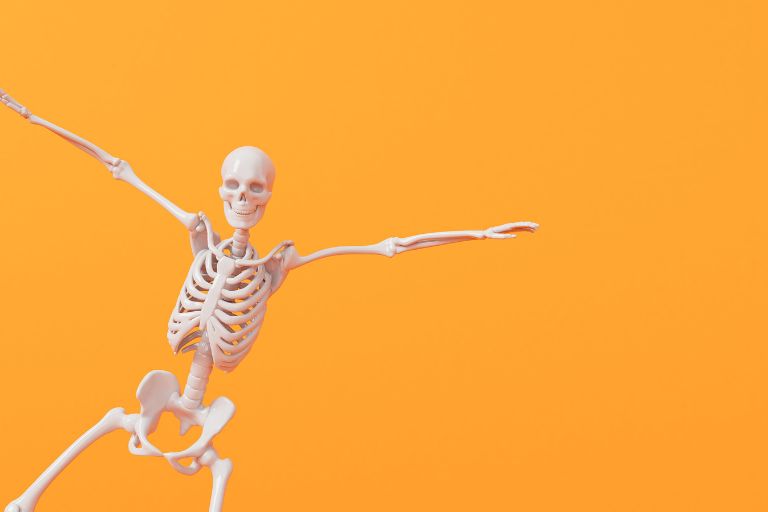 a skeleton on an orange background with wide spread arms